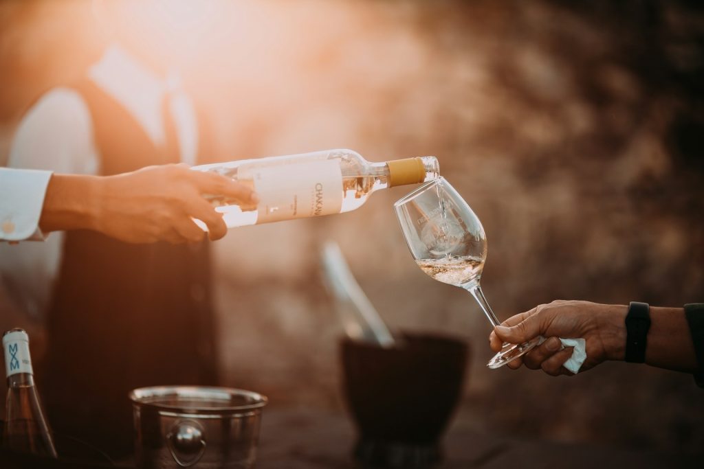 profession holding wine glass bottle at a wine tasting event