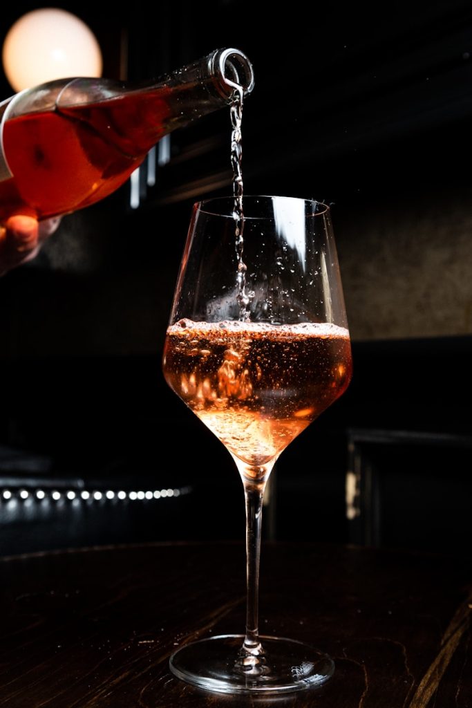 sommelier pours wine in glass