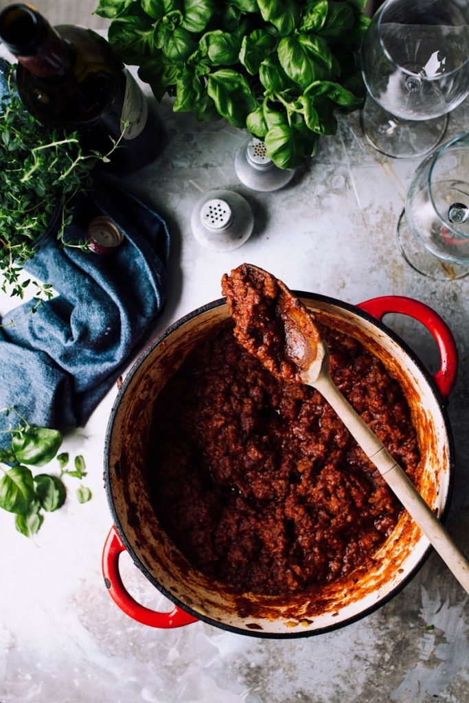 tomato meat sauce with bottle of wine and glass on the table